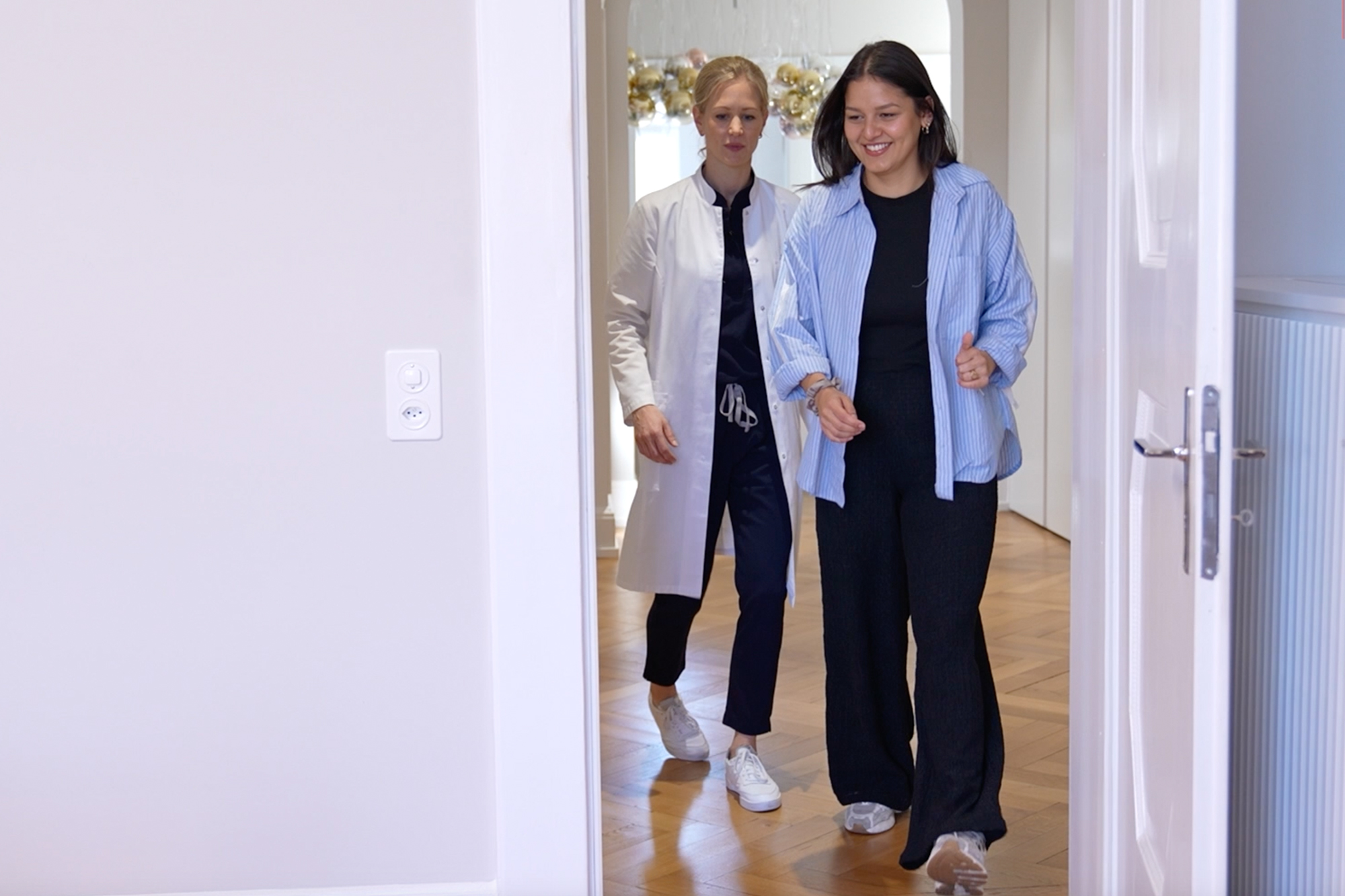 Ärztin mit Patientin in Praxis symbolisiert mehr Lebensqualität durch Brustverkleinerung